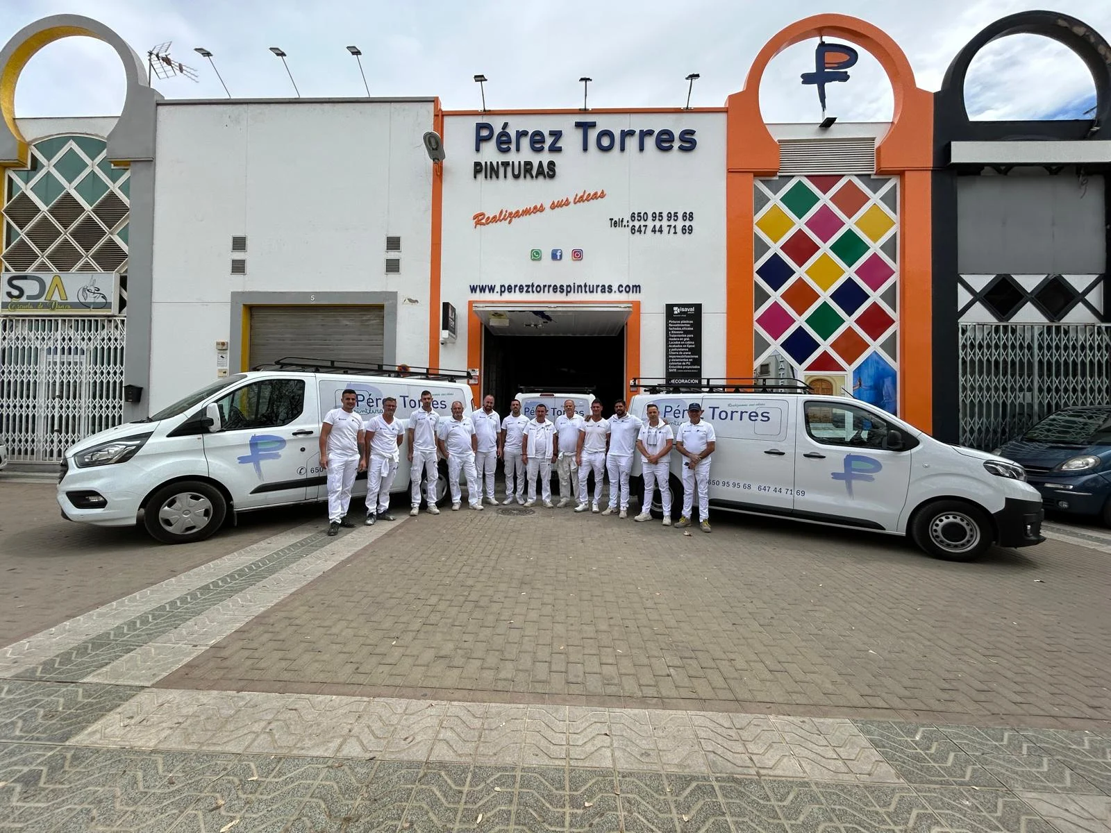 Equipo de Pérez Torres Pinturas frente a sus instalaciones y vehículos en Andújar