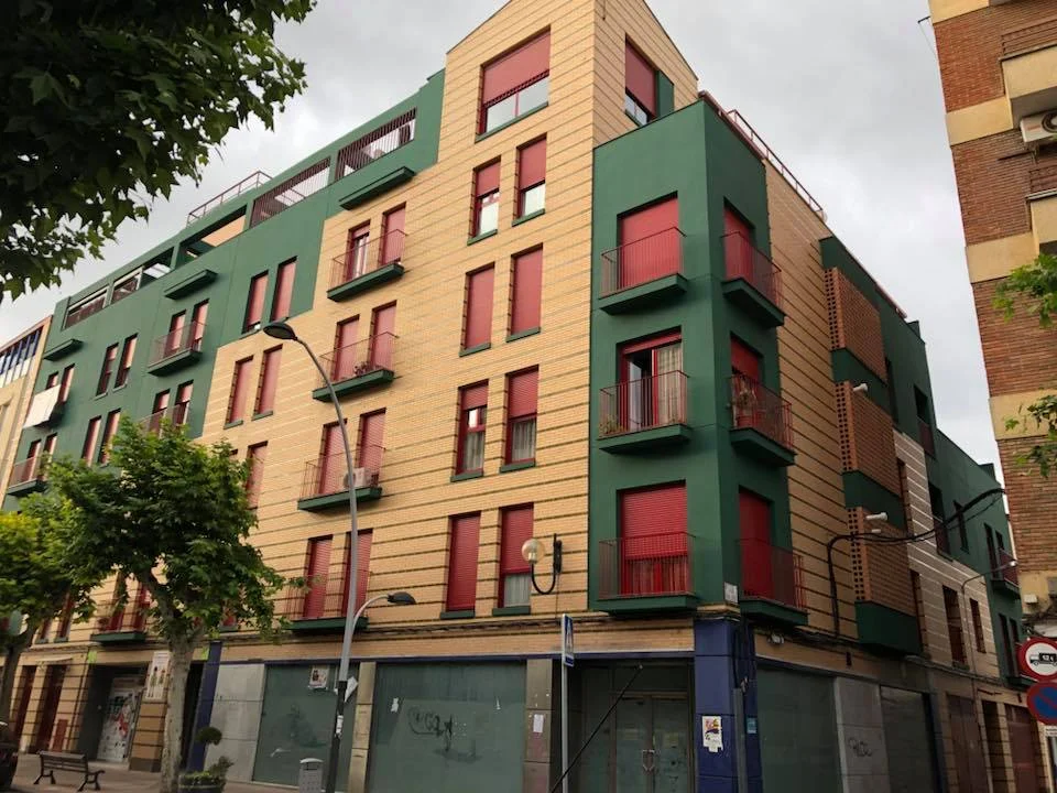 Fachada de edificio residencial en verde y terracota