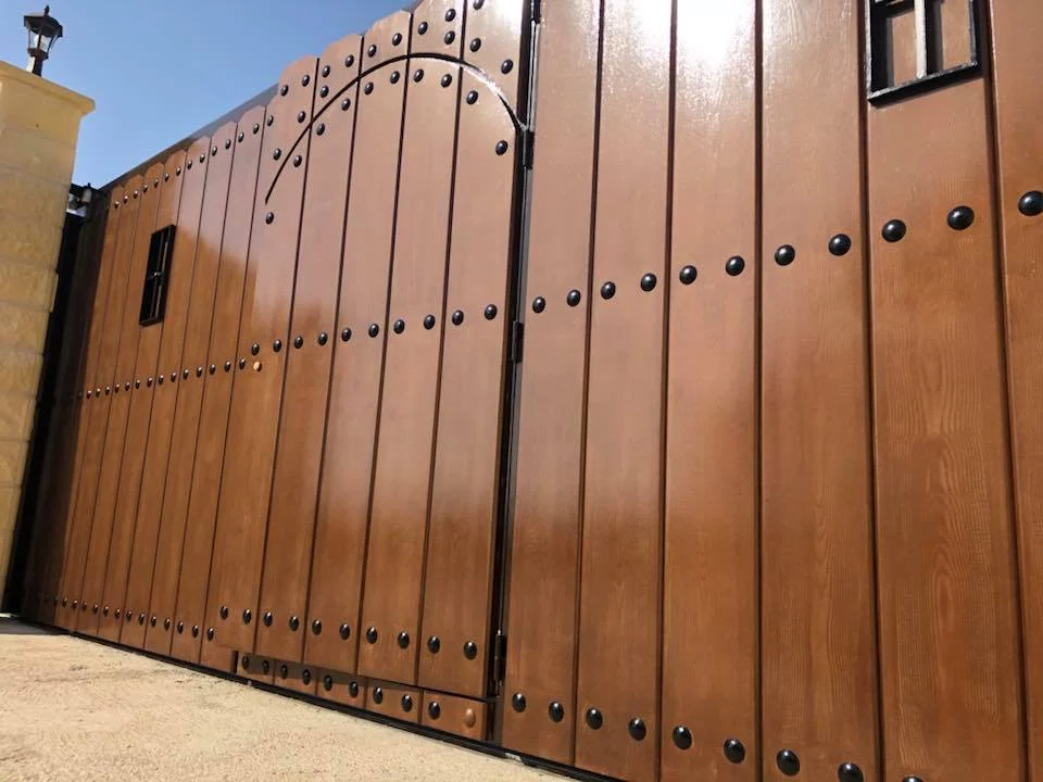 Puerta exterior de madera con herrajes decorativos